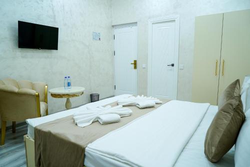 a bedroom with a bed with white towels on it at Astoria Inn Hotel in Toshkent-Passajir Bekati