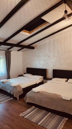 a bedroom with three beds in a room at Casa YDA in Horezu