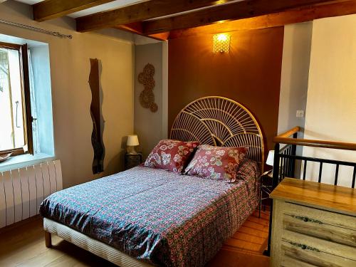 a bedroom with a bed with a large bedspread at Gîte Chez Charlot in Chanaz
