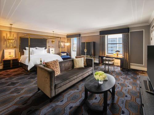 a hotel room with a bed and a couch at Fairmont Hotel Vancouver in Vancouver