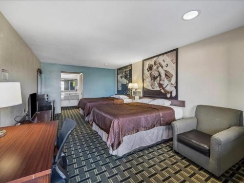 a hotel room with two beds and a desk at Hotel Blue Baytown, Texas in Baytown