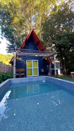 a house with a swimming pool in front of a house at Chale mundo da Lua 2 in Piedade