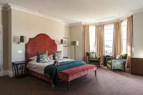 a bedroom with a large bed with a red headboard at Bedford Lodge Hotel & Spa in Newmarket