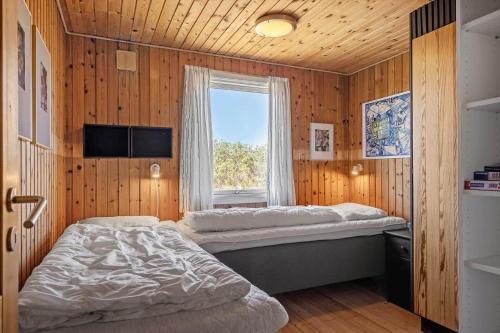 a bedroom with two beds and a window at 5514-Hvide-Sande-Riskrogvej-18-C in Havrvig