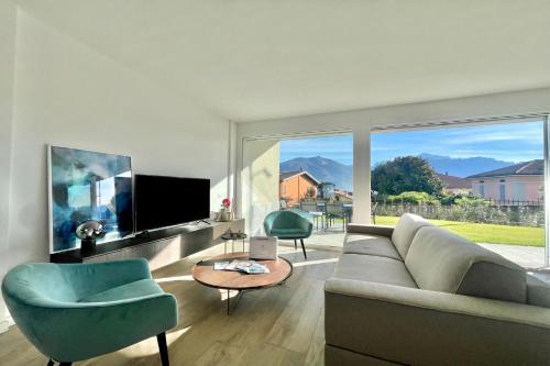 a living room with a couch and chairs and a large window at Condominio Modern House in Menaggio