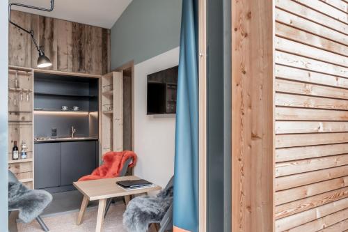 a room with a wooden wall and a table and chairs at Mondschein Hotel & Chalet Ski-In Ski-Out Luxus am Arlberg in Stuben am Arlberg