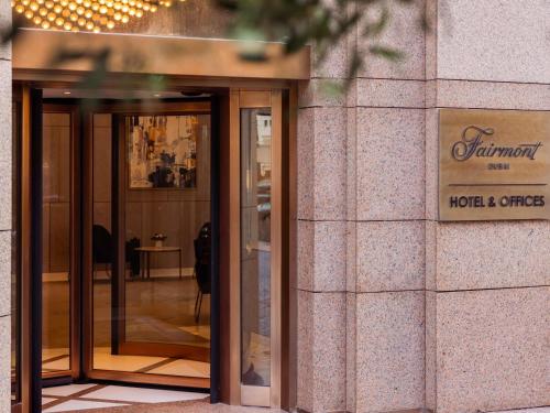a building with glass doors and a sign on it at Fairmont Dubai in Dubai