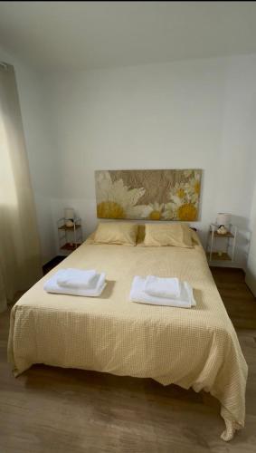 a bedroom with a bed with two towels on it at Apartamentos Canoa centro y playa in Sanlúcar de Barrameda
