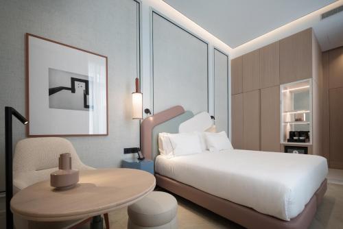 a bedroom with a bed and a table and a chair at Áurea Palacio de la Tinta by Eurostars Hotel Company in Málaga
