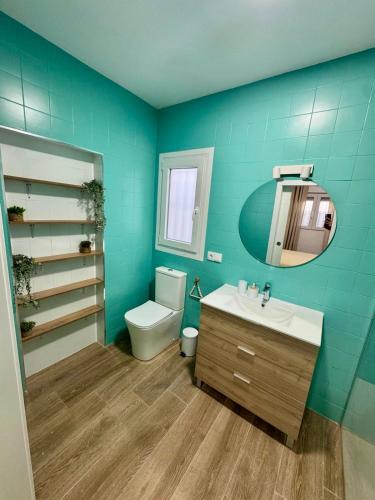 a bathroom with a toilet and a sink and a mirror at Apartamentos Canoa centro y playa in Sanlúcar de Barrameda