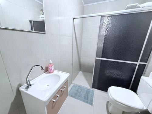 ein Badezimmer mit Dusche, Waschbecken und Toilette in der Unterkunft Repouso do Tchê in Foz do Iguaçu
