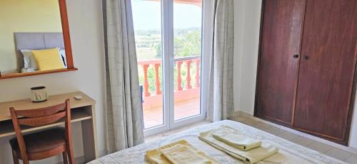 a room with a table and a desk and a window at Vivenda os Silvas in Lagos