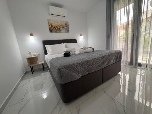 a bedroom with a large bed and a large window at Emma - Elena Peris Villas, By Idealstay Experience in Gouves