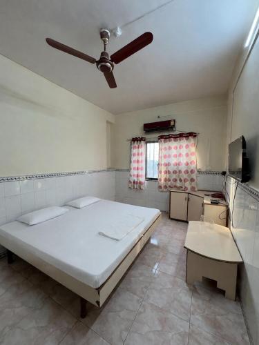 a bedroom with a bed and a ceiling fan at Hotel Shree Jay Amba Deluxe in Jaisingpur