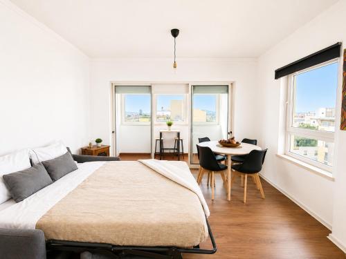 a bedroom with a bed and a table with chairs at Lisbon Lux T1 Pool Gym Tennis AC - Pouso dos Anjos Apartment in Lisbon
