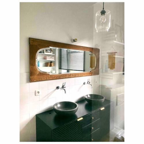a bathroom with two sinks and a mirror at Centrally located spacious family home in Tienen