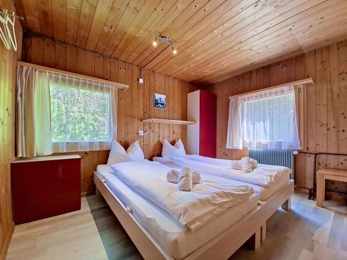 a bedroom with two beds in a wooden room at Chalet Egg-Isch by Interhome in Grindelwald