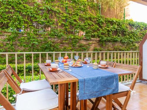 a wooden table with a blue table cloth and wine glasses at Apartment Buenos Aires by Interhome in Lloret de Mar
