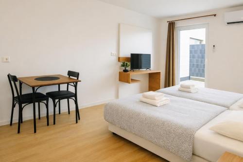 a room with two beds and a table and a desk at Ado Pension in Wedel