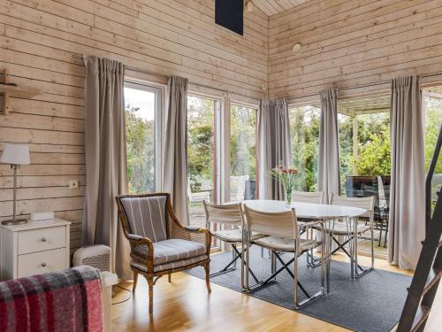 a dining room with a table and chairs and windows at Holiday Home Ringenäs by Interhome in Halmstad