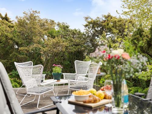 a table with chairs and a bowl of fruit on a table at Holiday Home Ringenäs by Interhome in Halmstad
