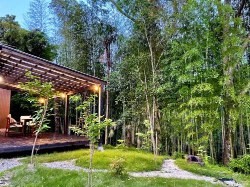 a house in the woods with a wooden deck at Gubo 里山ヴィレッジ 白木 in Katsuura