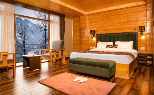 a bedroom with a bed and a large window at Valmere Bayul Shangri-La Resort in Lachung