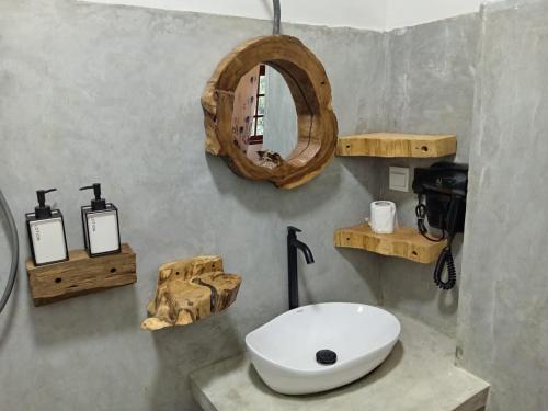 a bathroom with a sink and a mirror on the wall at The Wood Cottage in Elkaduwa