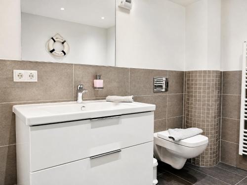 a bathroom with a white sink and a toilet at Ferienwohnung Meeresblick Haus Granitz in Prora in Binz