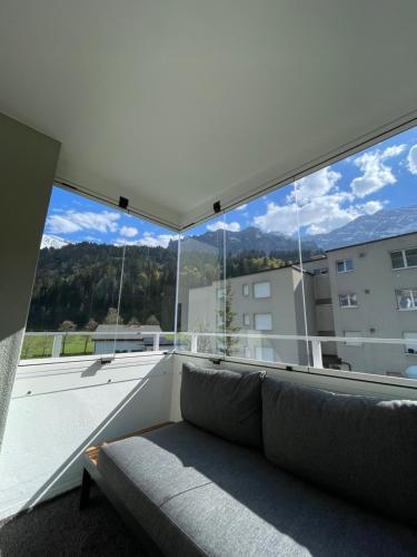 a living room with a couch in front of a large window at Spacious 2 bedroom apartment in Engelberg