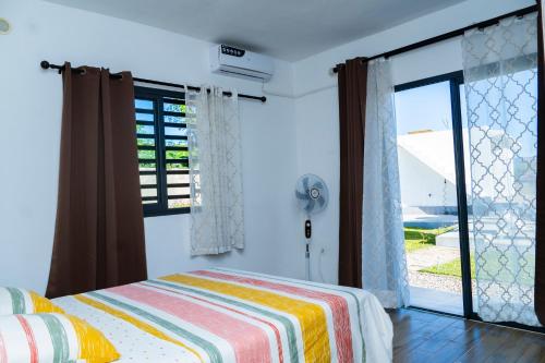 a bedroom with a bed and a large window at Résidence Vahi-Ni, Villa Faniry in Hell-Ville
