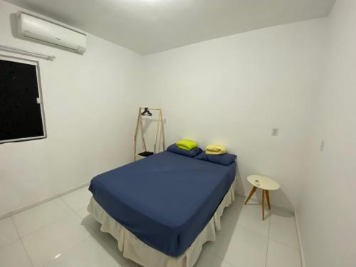 a bedroom with a blue bed in a white room at Apartamento no Crato, conforto e praticidade! in Crato