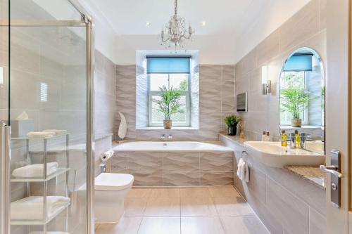 a bathroom with a tub and a toilet and a sink at Muckrach Country House in Skye of Curr