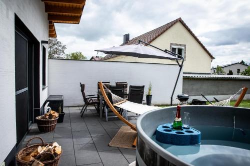 a bath tub sitting on top of a patio at Fewo River, Stilvolles Ferienhaus für Familien großer Garten, Spielplatz, Sauna & Badefass in Wendisch Rietz
