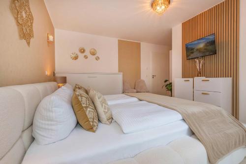 a bedroom with a large white bed with pillows at Ferienwohnung Goldkind in Kölpinsee