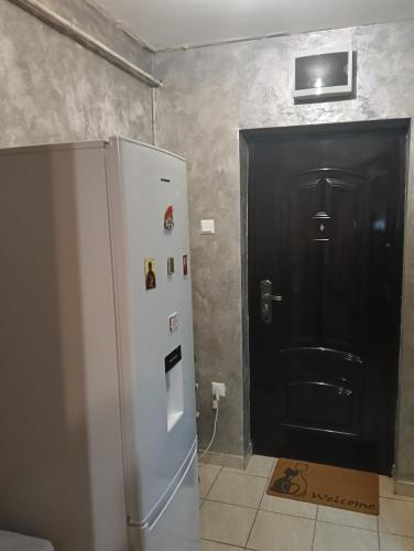 a kitchen with a refrigerator and a black door at casa lidia in Brăila