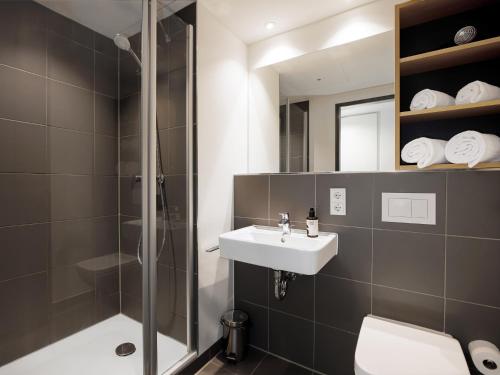 a bathroom with a shower and a sink and a toilet at smartments Berlin Karlshorst in Berlin