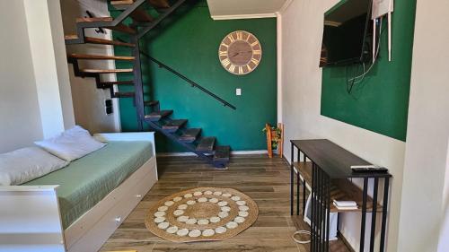 a living room with a staircase and a green wall at Azahares Apart in Bella Vista