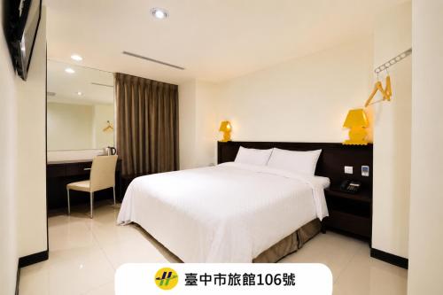 a hotel room with a white bed and a desk at 安可旅店 Bravo Hotel in Taichung
