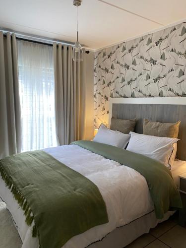 a bedroom with a large bed and a window at EdenNest in Boksburg