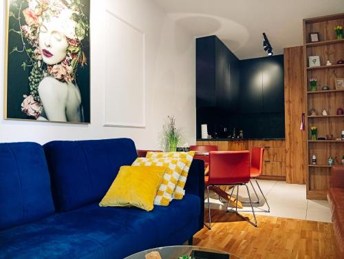 a living room with a blue couch and a table at Katowice Spodek in Katowice