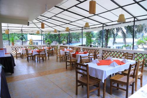 a dining room with tables and chairs in a restaurant at Rocy Hotel in Mbale