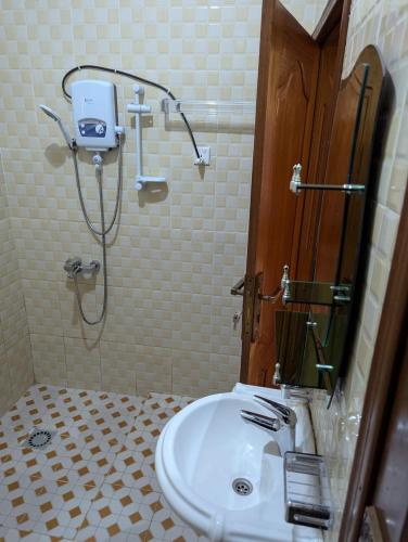 a bathroom with a shower and a sink at Gorilla Trekking Guest House in Ruhengeri
