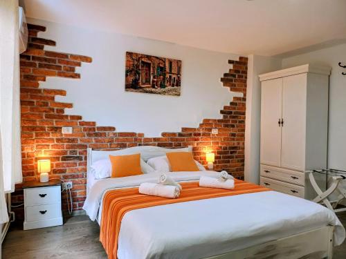 a bedroom with a brick wall and a bed at Camere de inchiriat La Locanda in Dubova