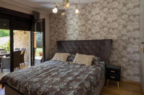 a bedroom with a bed with a headboard at Apartman Sara s vrtom in Vantačići
