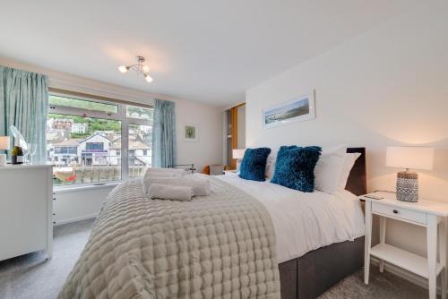 a bedroom with a large bed with blue pillows at 1 Bed in West Looe oc-1west in Looe