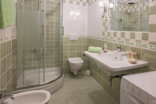 a bathroom with a sink and a toilet and a shower at Apartman Sara s vrtom in Vantačići