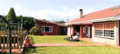 a house with a red roof and a yard at Guirigay CASA CON PISCINA in Muros de Nalón