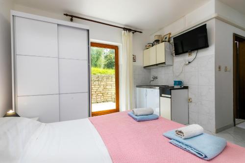 a bedroom with a large bed with towels on it at Apartments Pino Rabac in Rabac