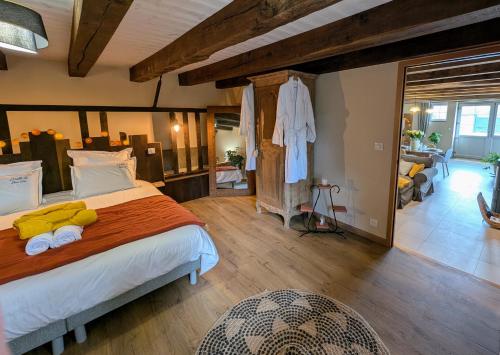 a bedroom with a large bed and a living room at Gite L étable du Bien Etre in Ray-sur-Saône
